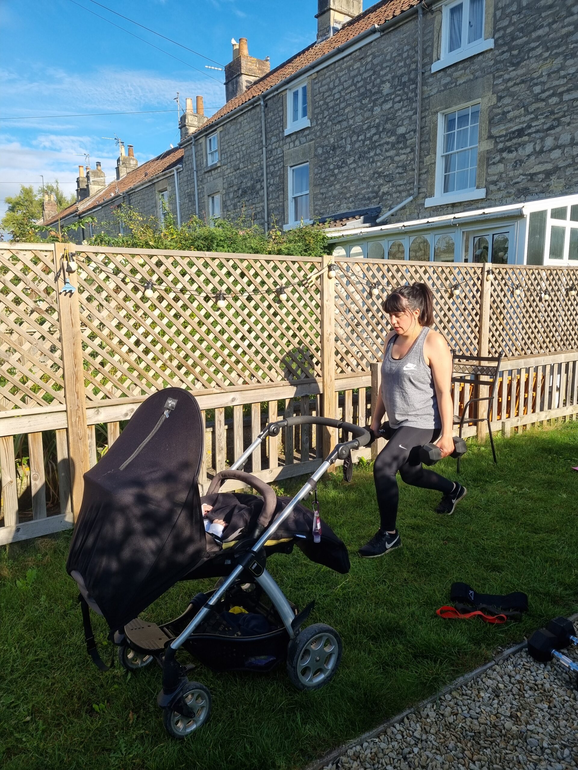 Woman doing lunges next to baby in pram